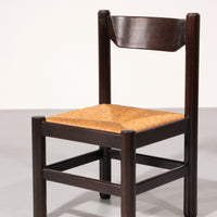 Eethoek geïnspireerd op Vico Magistretti, met zes elegant opnieuw gevlochten stoelen en een tafel.