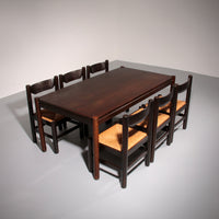 Eethoek geïnspireerd op Vico Magistretti, met zes elegant opnieuw gevlochten stoelen en een tafel.