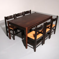 Eethoek geïnspireerd op Vico Magistretti, met zes elegant opnieuw gevlochten stoelen en een tafel.